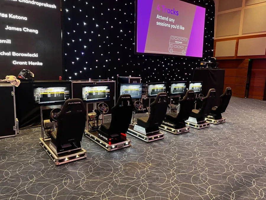 Row of networked racing simulators at a conference